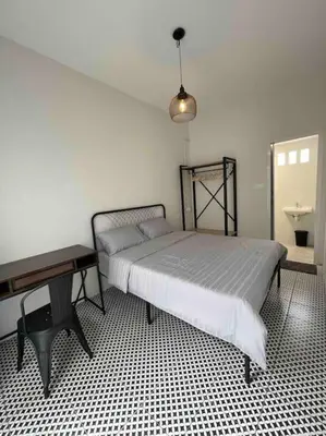 a bedroom with a bed and a table and a desk at Modern Victorian Homestay in George Town