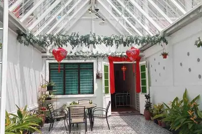 a patio with a table and chairs and a glass ceiling at Modern Victorian Homestay in George Town