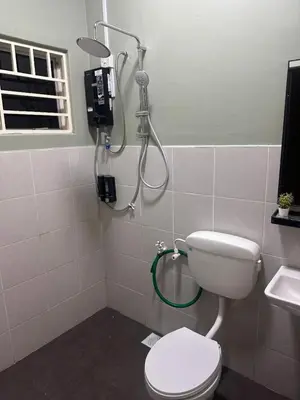 a bathroom with a shower and a toilet and a sink at Humaira Homestay Teluk Intan in Teluk Intan