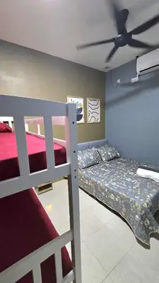 a bedroom with two bunk beds and a ceiling fan at Humaira Homestay Teluk Intan in Teluk Intan