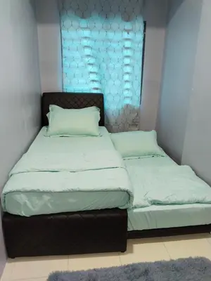 two beds in a small room with a window at Homestay Lyn Impian in Tanjung Rambutan
