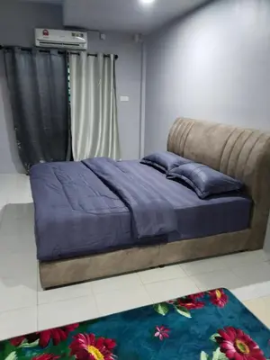 a bedroom with a bed with blue sheets and a window at Homestay Lyn Impian in Tanjung Rambutan