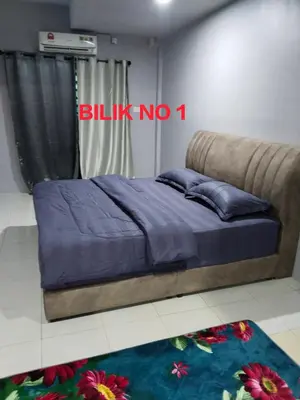 a bedroom with a bed with a blue blanket at Homestay Lyn Impian in Tanjung Rambutan