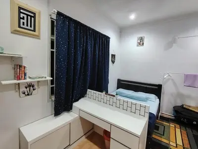 a room with a bed and a desk and a window at Sri MaLati Homestay and Event Space in Balik Pulau