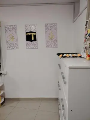 a white kitchen with drawings on the wall at Sri MaLati Homestay and Event Space in Balik Pulau