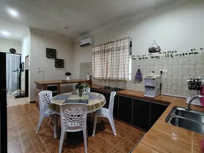 a kitchen with a table and chairs and a sink at Sri MaLati Homestay and Event Space in Balik Pulau
