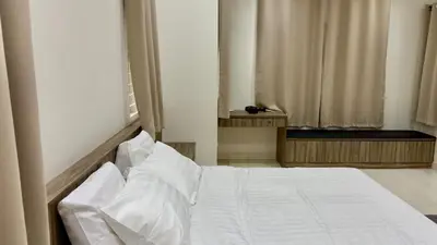 a bedroom with a bed with white sheets and a window at no7 HOMESTAY in Tanjung Karang