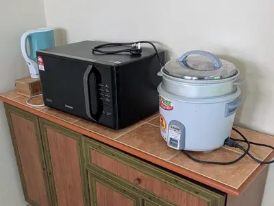 a microwave and a slow cooker on top of a counter at Musa Seri Iskandar Homestay in Seri Iskandar