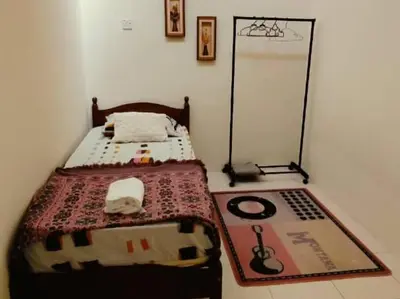 a room with a bed in a room with a poster at Musa Seri Iskandar Homestay in Seri Iskandar
