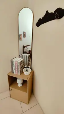 a shelf with books and a mirror in a room at Musa Seri Iskandar Homestay in Seri Iskandar