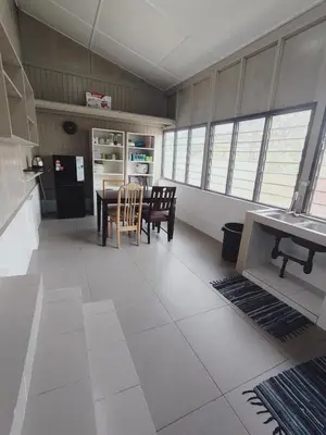 a kitchen with a table and chairs in a room at Rizkie homestay in Tanah Rata