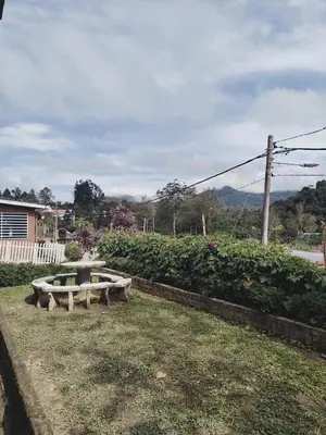 a picnic table in a yard with a field at Rizkie homestay in Tanah Rata