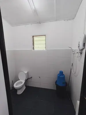 a bathroom with a toilet and a window at Rizkie homestay in Tanah Rata