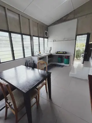 a kitchen with a table and chairs in a room at Rizkie homestay in Tanah Rata