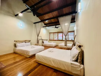 two beds in a room with wooden floors at New Takekaze Retreat \u7af9\u98ce\u4e4b\u5bb6 for 14 pax at Central Penang in George Town