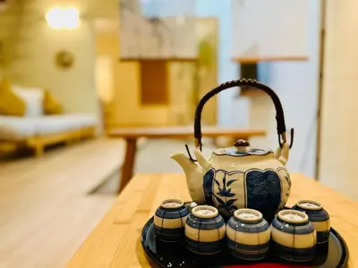a tea pot sitting on a table with four cups at New Takekaze Retreat \u7af9\u98ce\u4e4b\u5bb6 for 14 pax at Central Penang in George Town