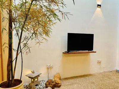 a flat screen tv on a wall next to a tree at New Takekaze Retreat \u7af9\u98ce\u4e4b\u5bb6 for 14 pax at Central Penang in George Town