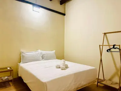 a bedroom with a white bed with a stuffed animal on it at New Takekaze Retreat \u7af9\u98ce\u4e4b\u5bb6 for 14 pax at Central Penang in George Town