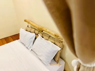 a woman standing next to a bed with white pillows at New Takekaze Retreat \u7af9\u98ce\u4e4b\u5bb6 for 14 pax at Central Penang in George Town