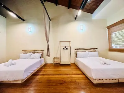 two beds in a room with wooden floors at New Takekaze Retreat \u7af9\u98ce\u4e4b\u5bb6 for 14 pax at Central Penang in George Town