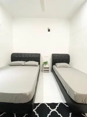 a bedroom with two beds and a rug at ROOMSTAY KOME Merapoh in Perhentian Merapuh Baharu