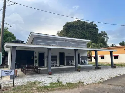 a white building with a picnic table in front of it at ROOMSTAY KOME Merapoh in Perhentian Merapuh Baharu