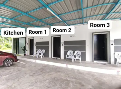 a group of white chairs sitting in a building at ROOMSTAY KOME Merapoh in Perhentian Merapuh Baharu