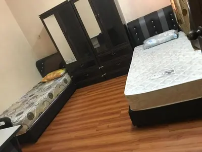 two beds in a room with a wooden floor at 3999 Sejahtera Homestay in Lunas