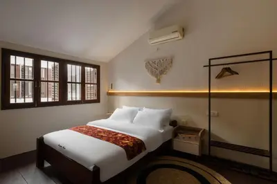 a bedroom with a large white bed and two windows at Armenian House by IIP in George Town