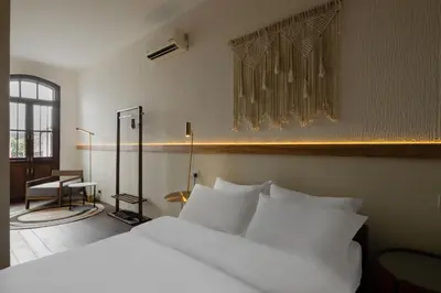 a bedroom with a large white bed and a desk at Armenian House by IIP in George Town