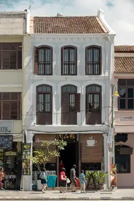 a white building with people walking in front of it at Armenian House by IIP in George Town