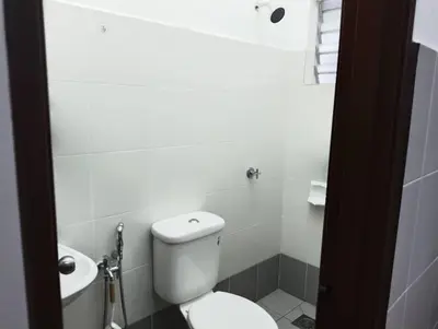 a white bathroom with a toilet and a sink at Nufa homestay-seri iskandar in Seri Iskandar