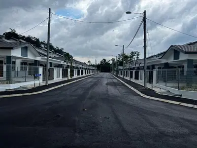 an empty street in a residential neighborhood with houses at Nufa homestay-seri iskandar in Seri Iskandar