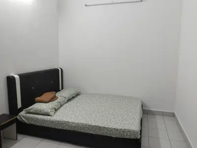 a bed in a room with a black frame at Nufa homestay-seri iskandar in Seri Iskandar