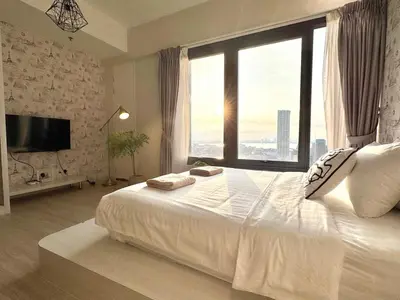 a bedroom with a large white bed with a large window at Tropicana 218 Macalister #Georgetown #Infinity Pool #2pax studio suite #1 Queen #Quality well maintained #Private host in George Town