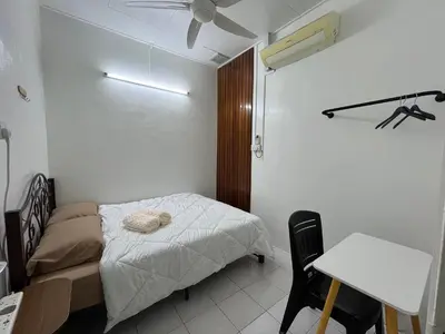 a bedroom with a bed and a desk and a table at Green Woody Homestay in Ipoh