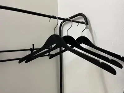 a pair of black hangers hanging on a rack at Green Woody Homestay in Ipoh
