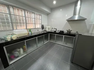 a kitchen with a sink and a stove at Green Woody Homestay in Ipoh