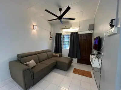 a living room with a couch and a ceiling fan at Green Woody Homestay in Ipoh