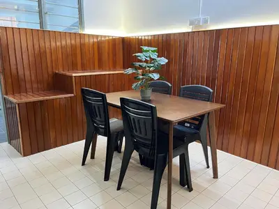 a table with four chairs and a potted plant on it at Green Woody Homestay in Ipoh