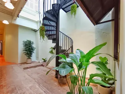 a hallway with plants and a spiral staircase at Pine Muntri in George Town