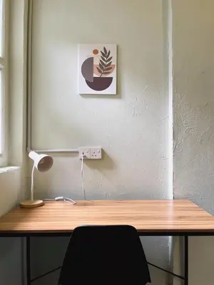 a desk with a lamp and a picture on a wall at Pine Muntri in George Town