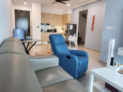 a living room with a blue chair and a table at CATAILIS Metropol Serviced Apartment Bandar Perda Bukit Mertajam near Penang Bridge in Bukit Mertajam
