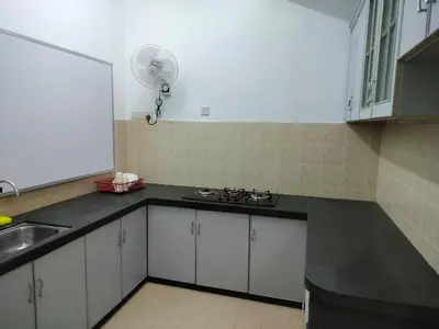 a kitchen with white cabinets and a sink and a fan at CMN Hotel & Homestay in Sungai Petani