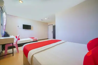 a bedroom with a bed and a desk and a tv at CMN Hotel & Homestay in Sungai Petani