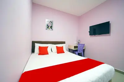 a bedroom with a large bed with red pillows at CMN Hotel & Homestay in Sungai Petani
