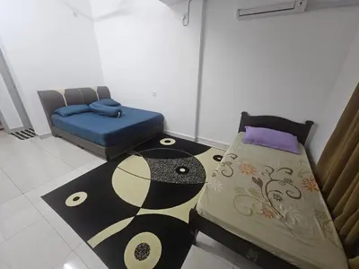 a small room with two beds and a rug at alif homestay kulim in Kulim