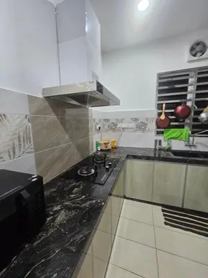 a kitchen with a black and white counter top at alif homestay kulim in Kulim