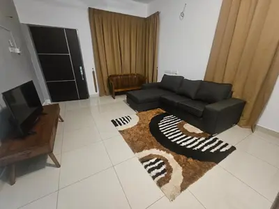 a living room with a black couch and a rug at alif homestay kulim in Kulim