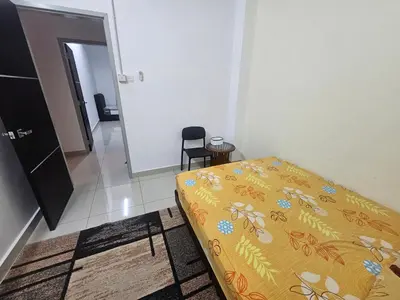 a bedroom with a bed and a chair in a room at alif homestay kulim in Kulim